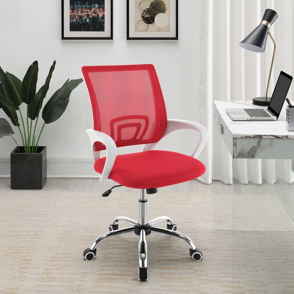 A red office chair is sitting in front of a desk with a laptop on it.