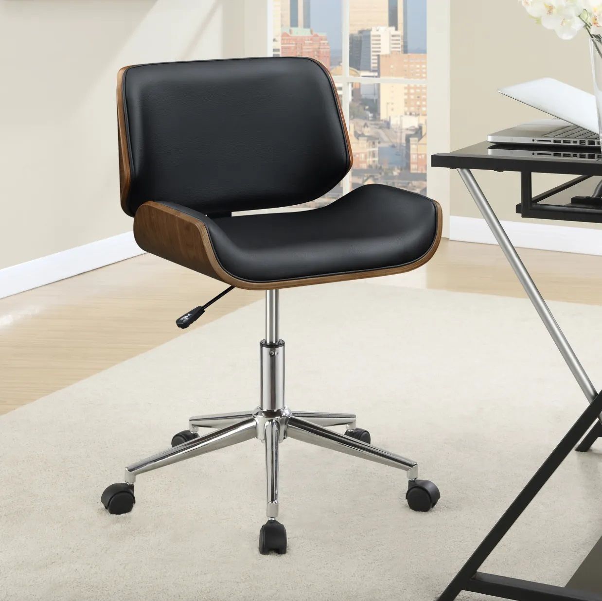 A black office chair sits in front of a desk