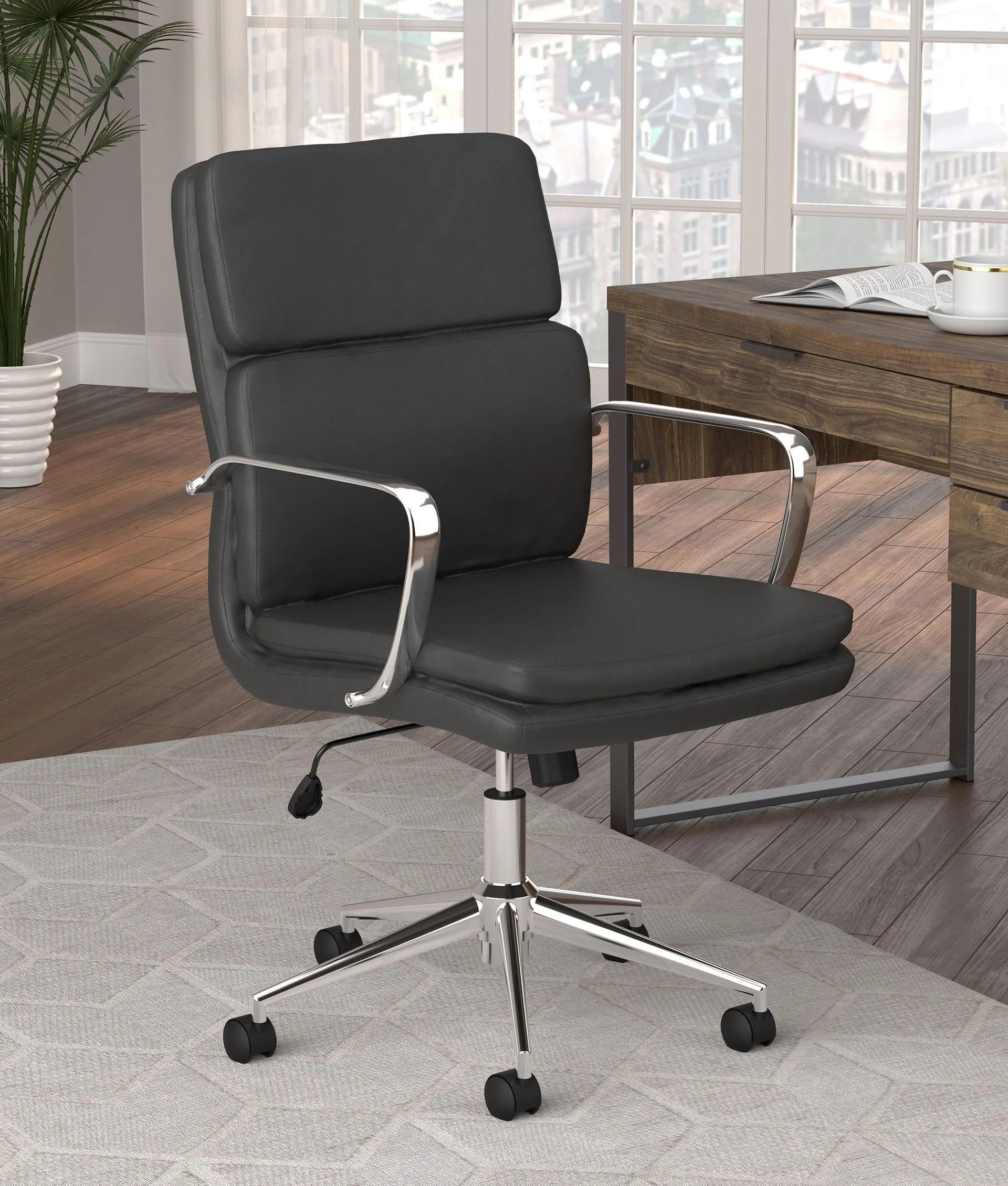 A black office chair is sitting in front of a desk in a room.