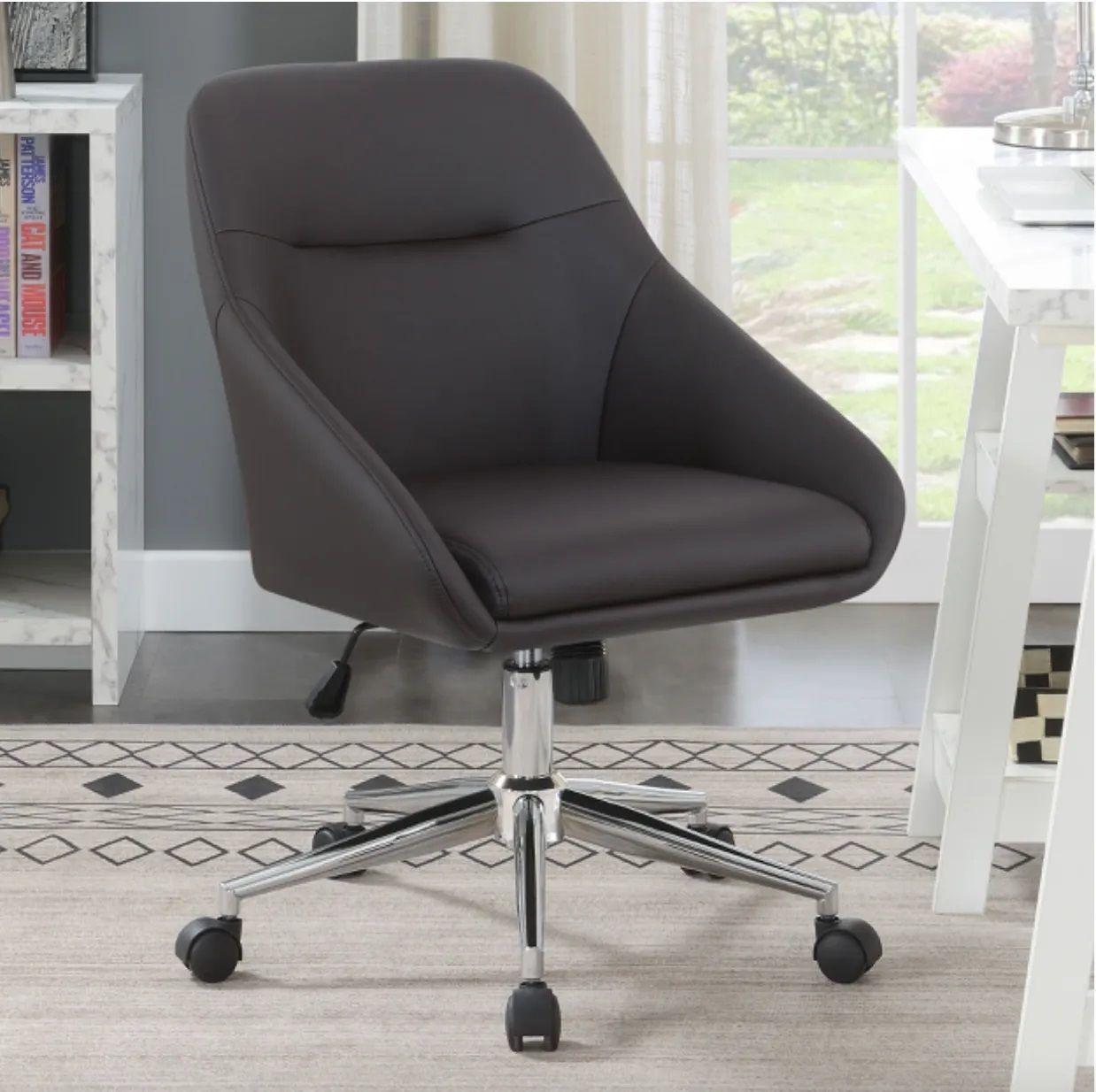 A black office chair is sitting on a rug next to a desk
