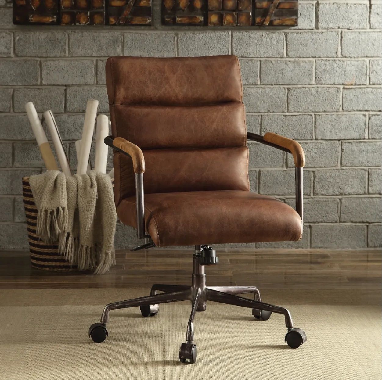 A brown leather office chair is sitting in front of a brick wall