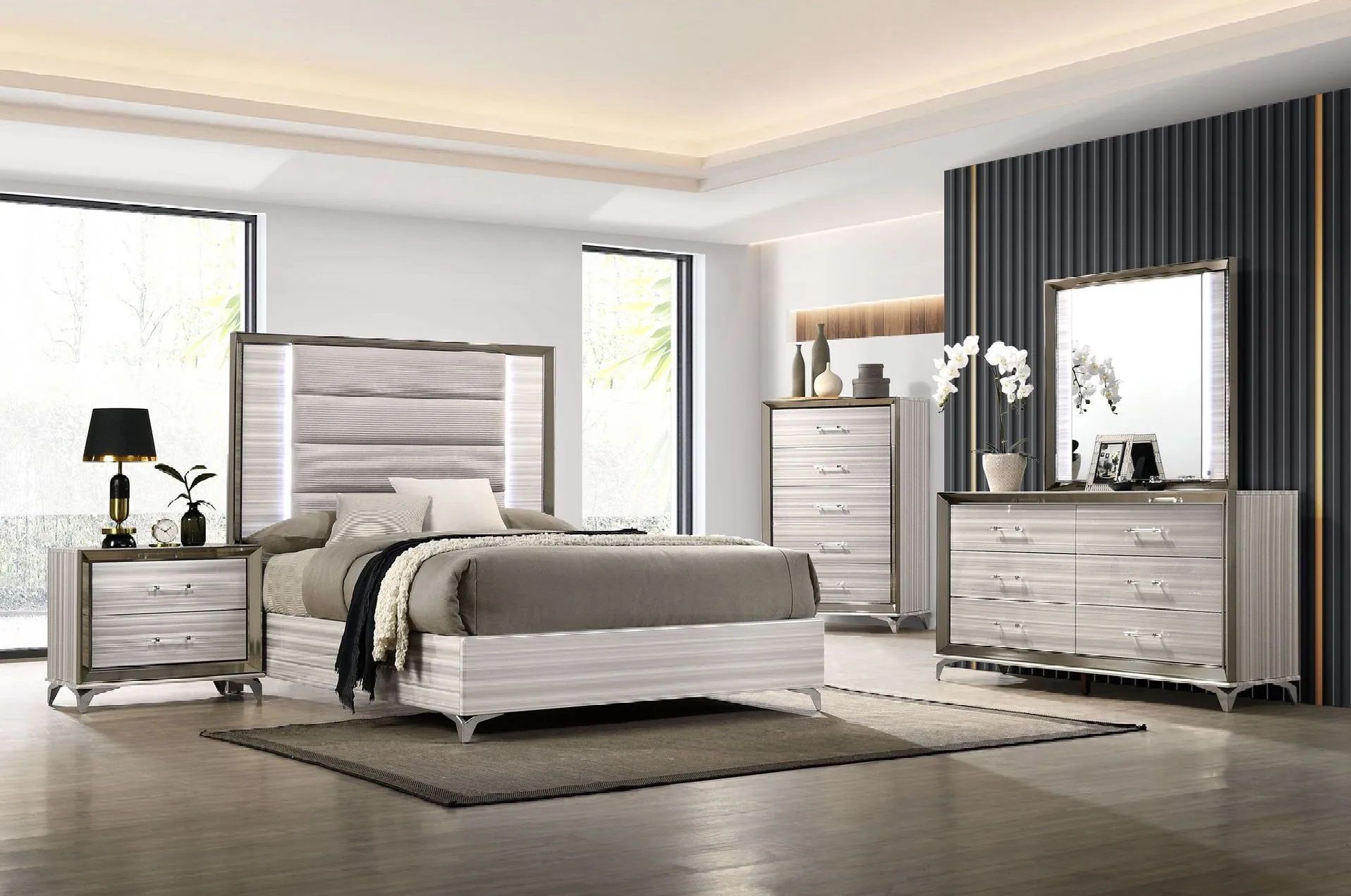 A bedroom with a bed , dresser , nightstand and mirror.