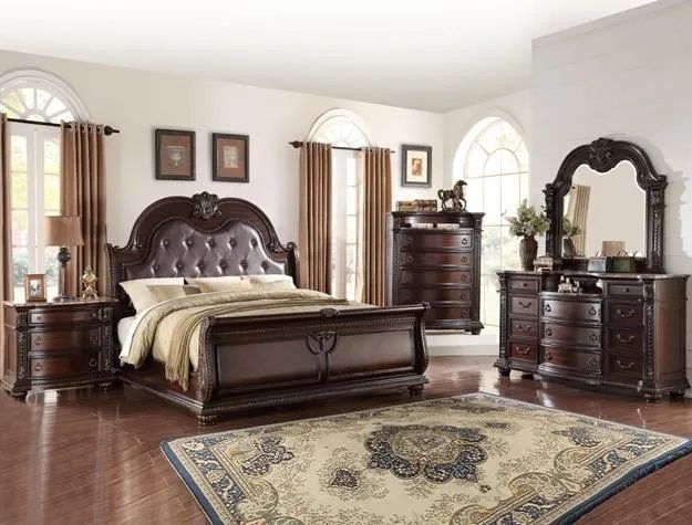 A bedroom with a bed , dresser , nightstand , mirror and rug.