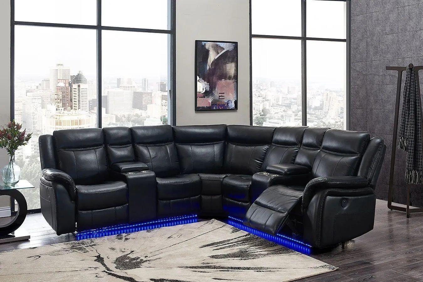 A black leather sectional couch is sitting in a living room next to a window.