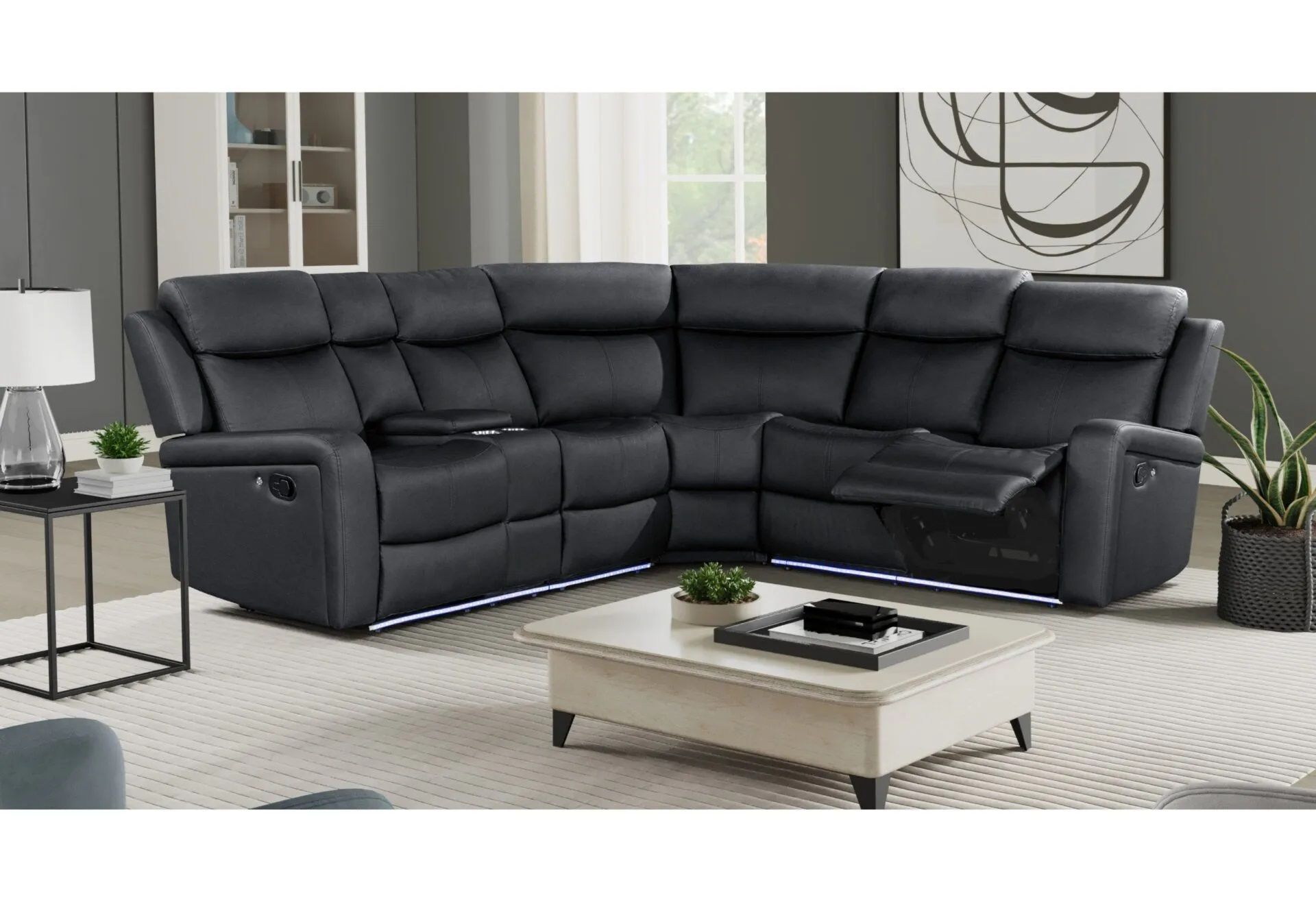 A living room with a black sectional couch and a white coffee table.