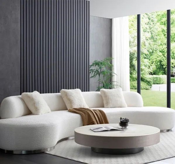 A living room with a white sectional couch and a round coffee table