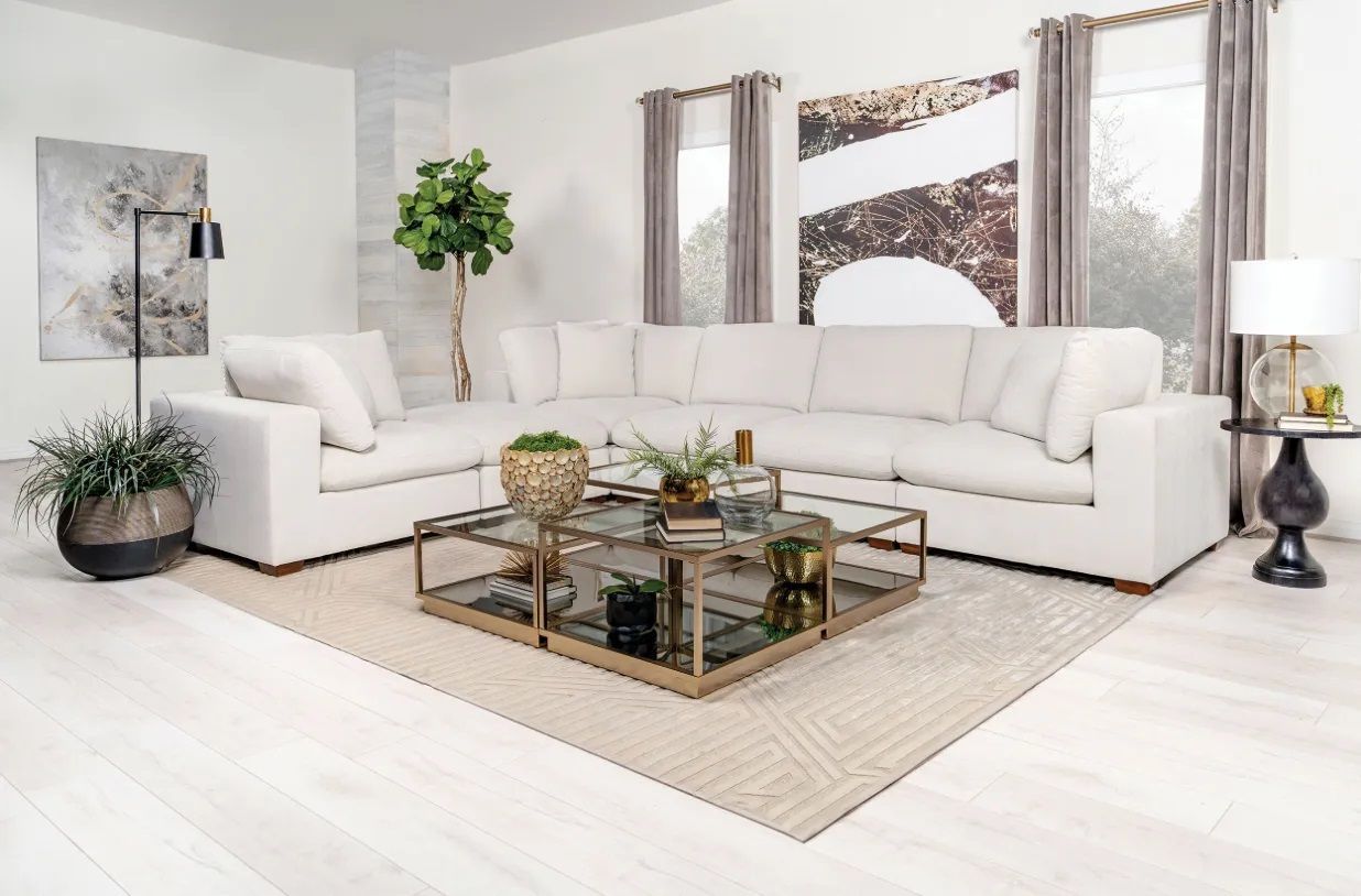 A living room with a white sectional couch and a coffee table.