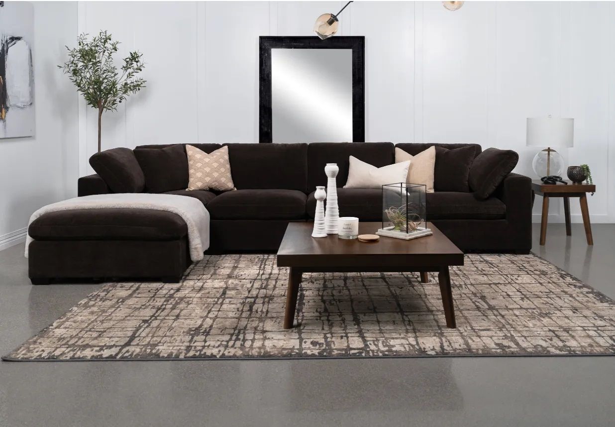 A living room with a large sectional couch and a coffee table