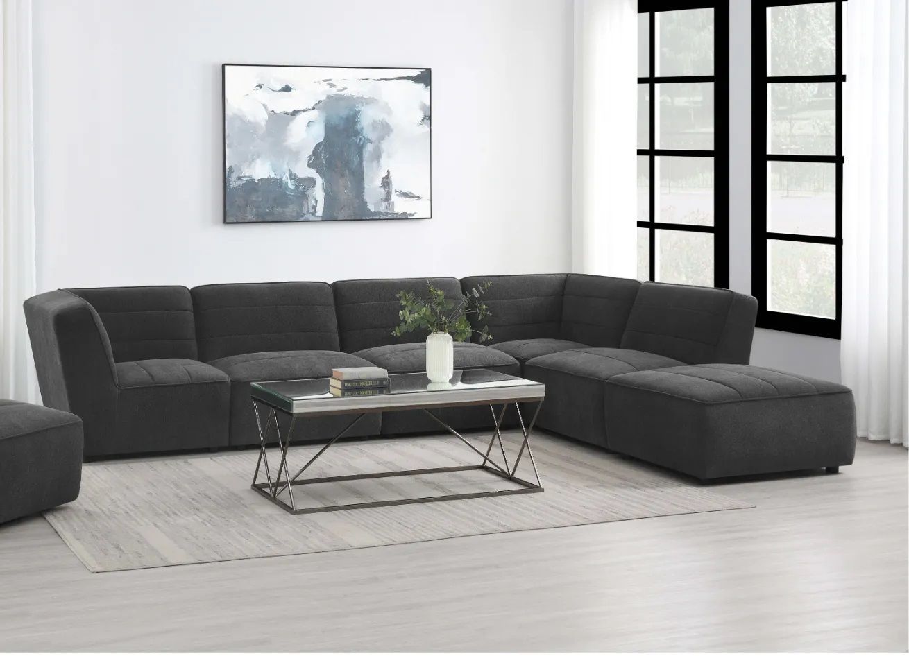 A living room with a large sectional couch and a coffee table.