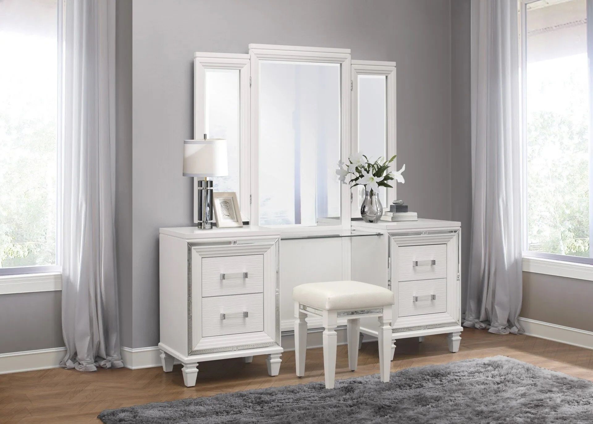 A white vanity with a mirror and stool in a bedroom.