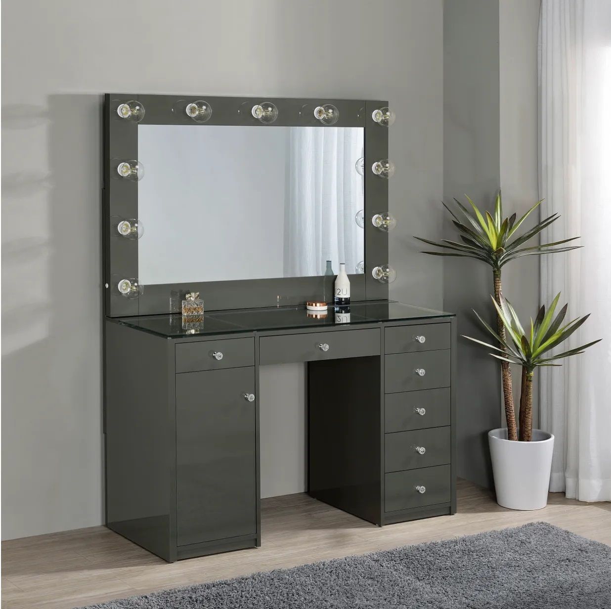 A dressing table with a mirror and lights on it