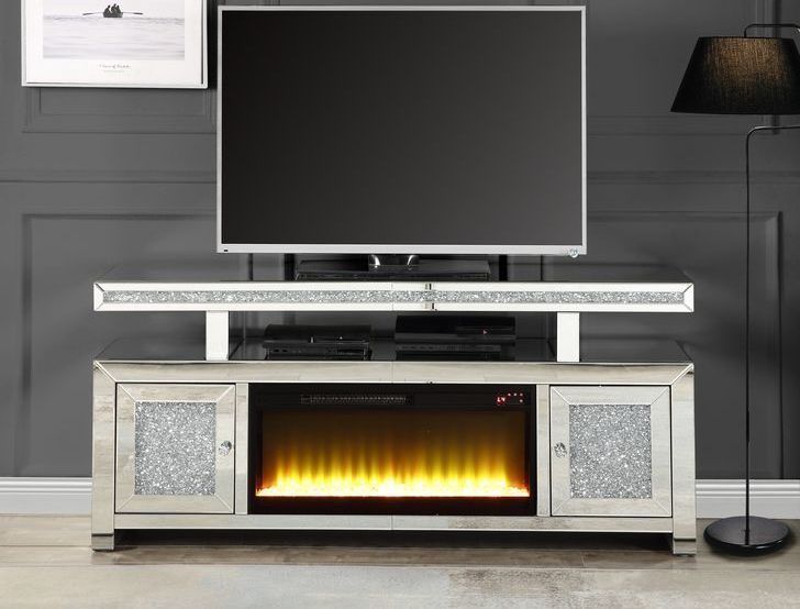A flat screen tv is sitting on top of a tv stand with a fireplace built into it.