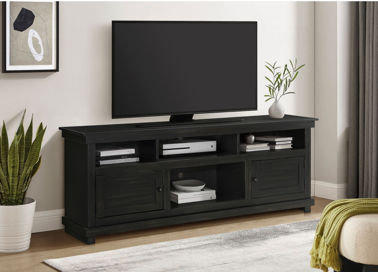 A black tv stand with a flat screen tv on it in a living room.