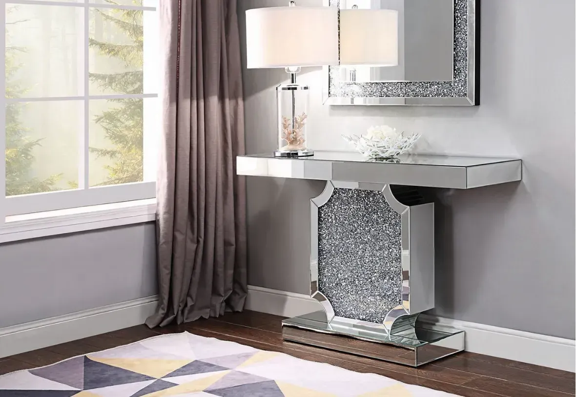 There is a mirror on the wall above the console table.