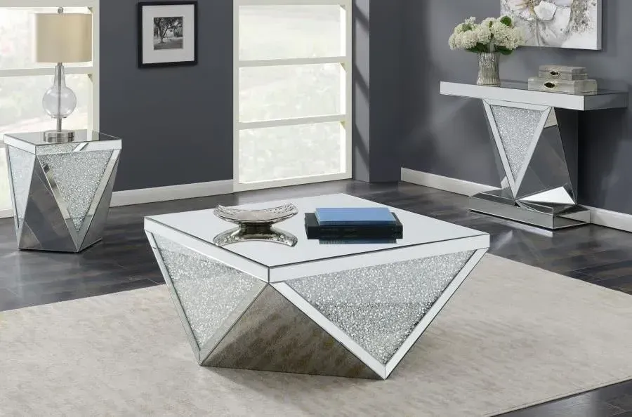 A living room with a mirrored coffee table and two side tables.