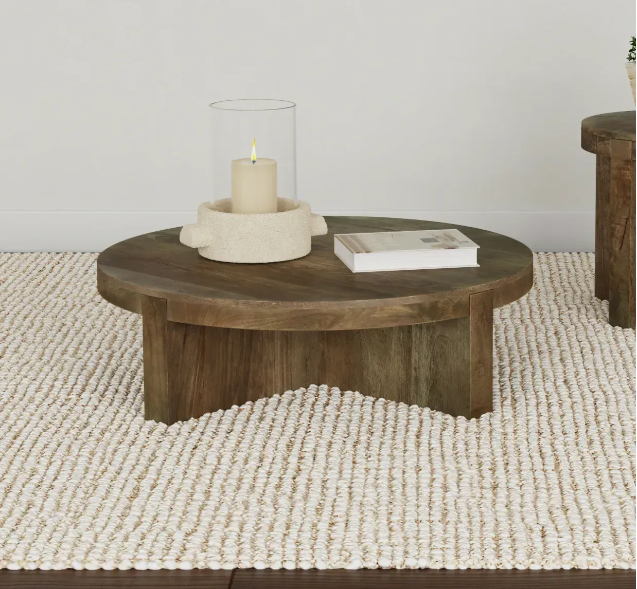 A wooden coffee table with a candle and a book on it