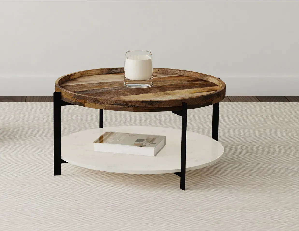 A round wooden coffee table with a candle and a book on it.