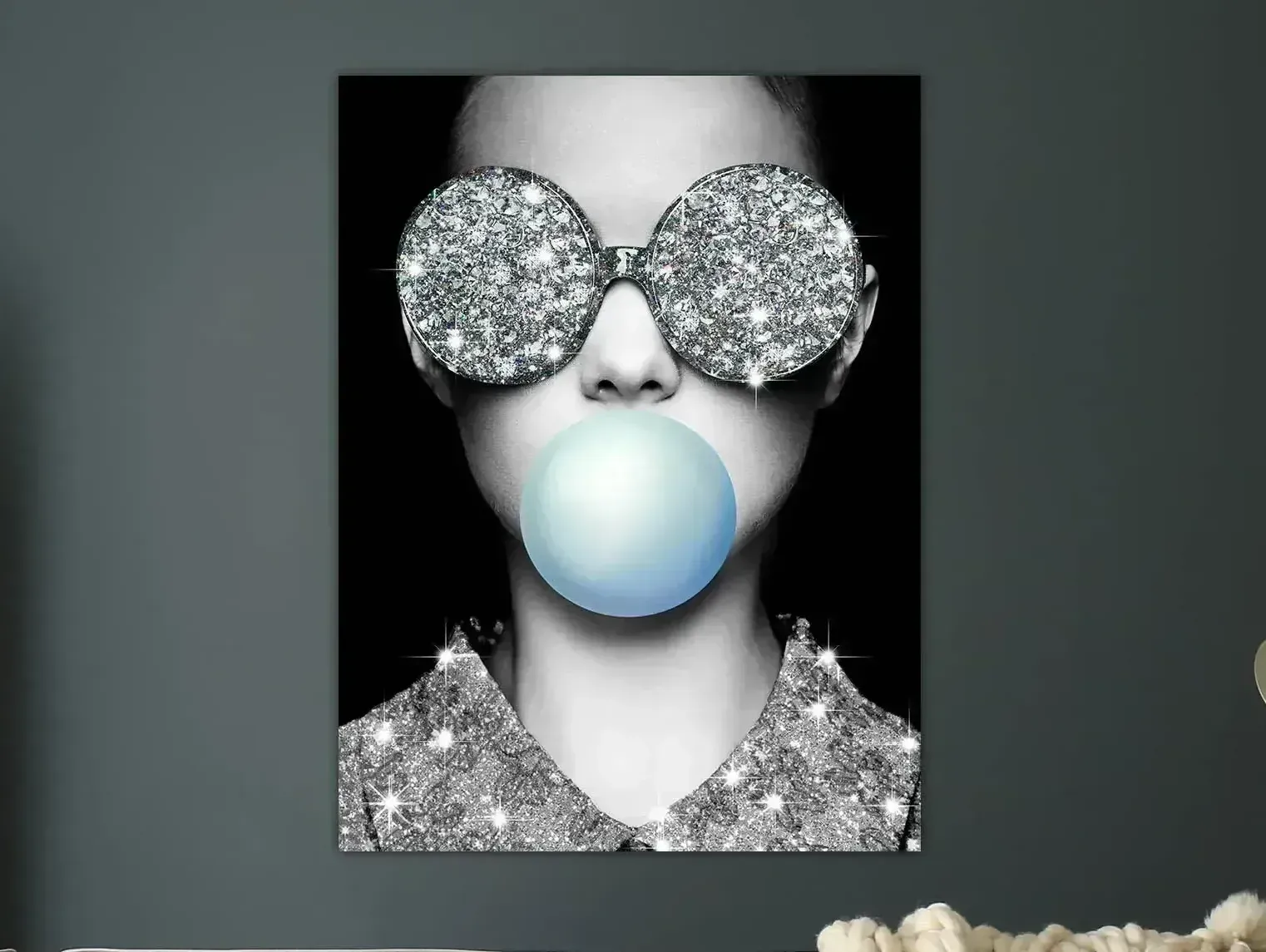A girl wearing sunglasses blowing a blue bubble gum