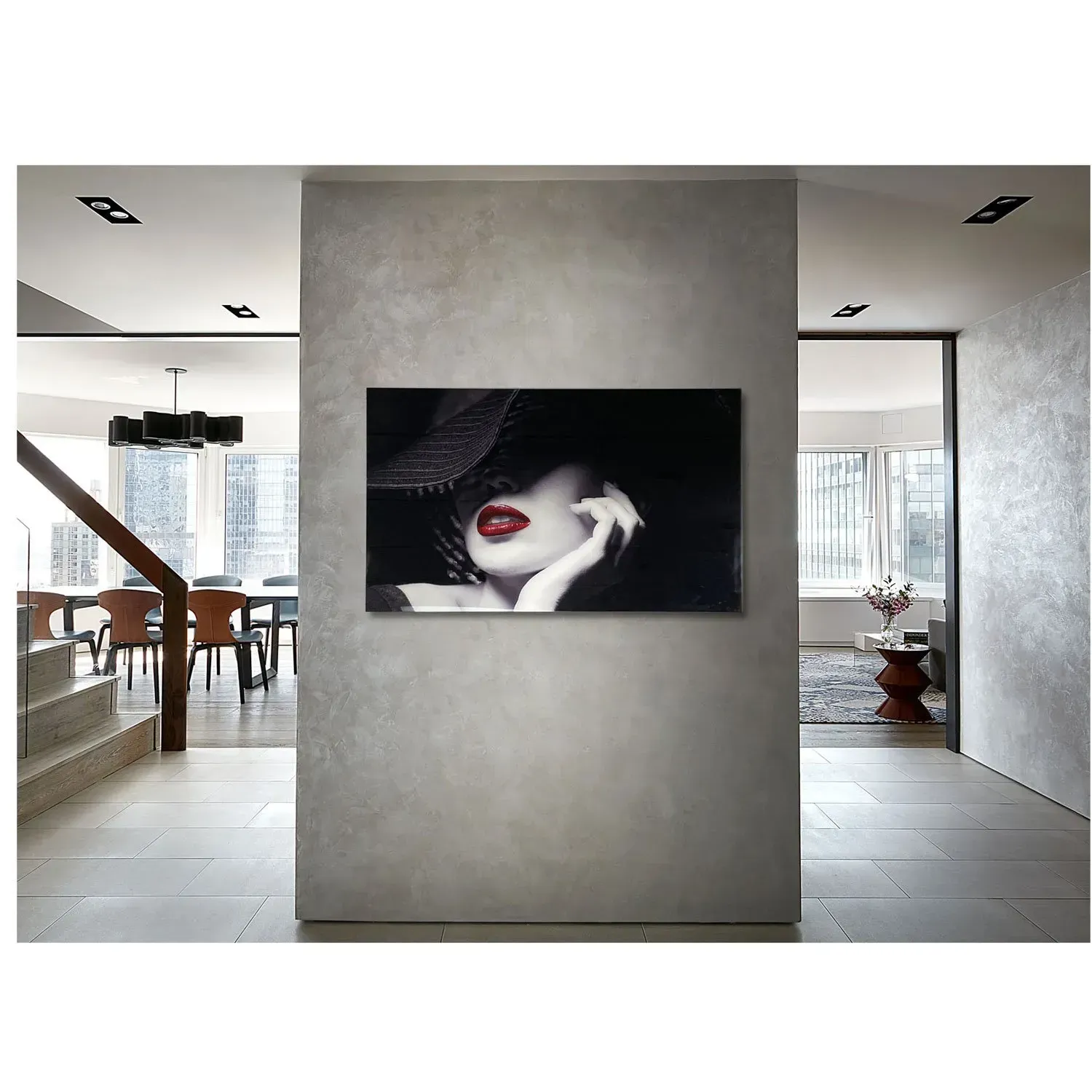 A painting of a woman with red lips is hanging on a wall