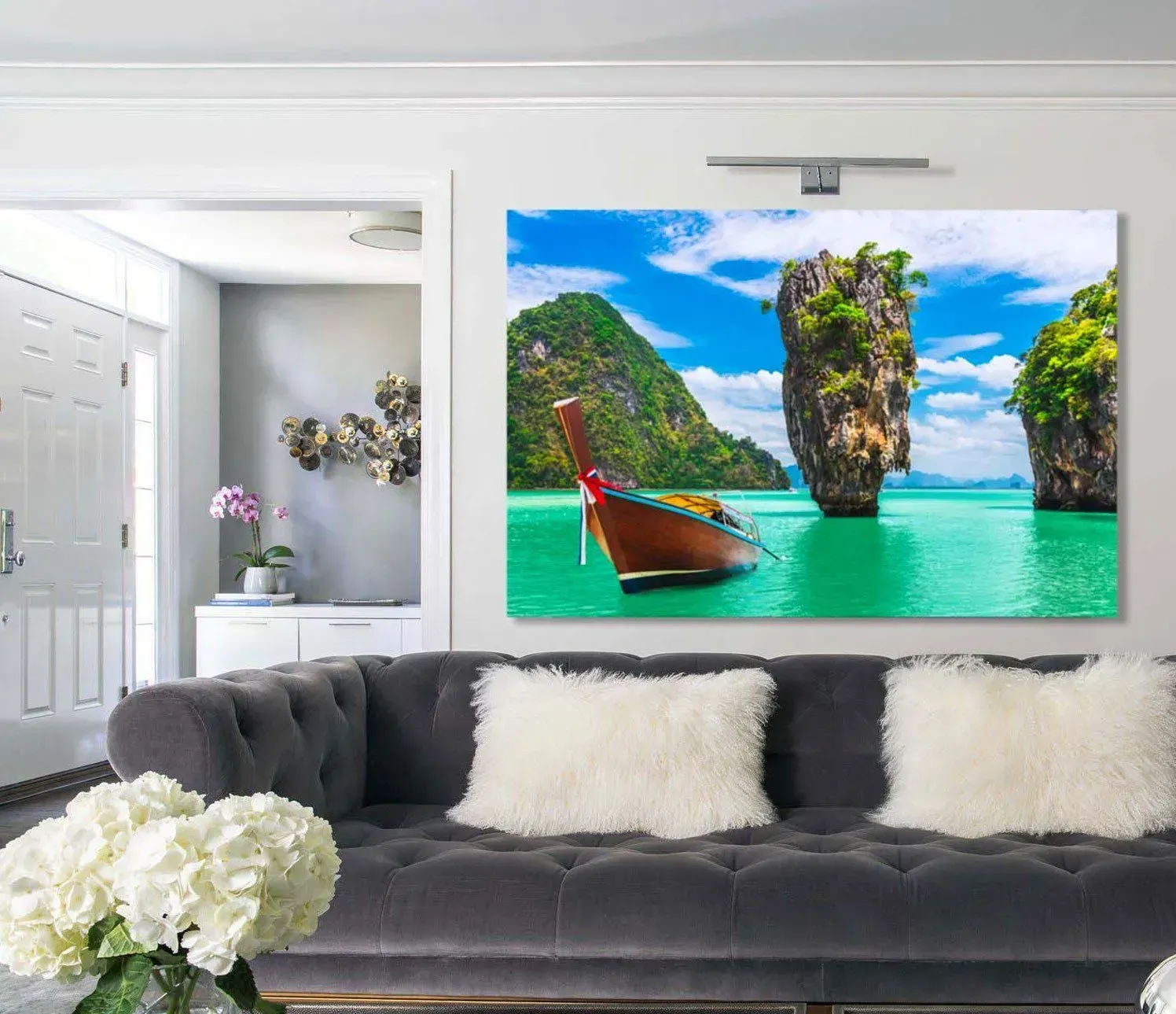 A living room with a couch and a painting of a boat in the water