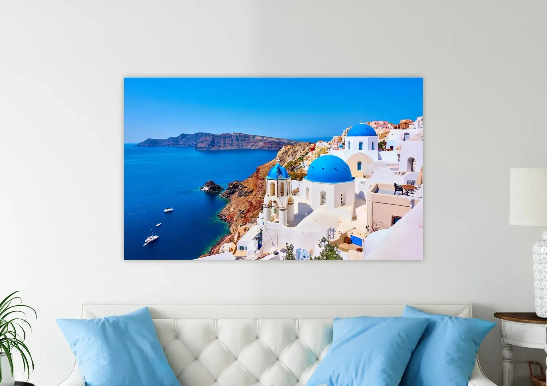 A living room with a couch , pillows , and a painting on the wall.