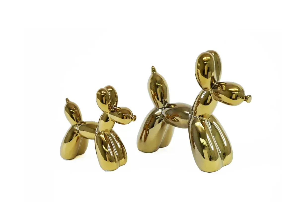 Two gold balloon dogs are sitting next to each other on a white background.