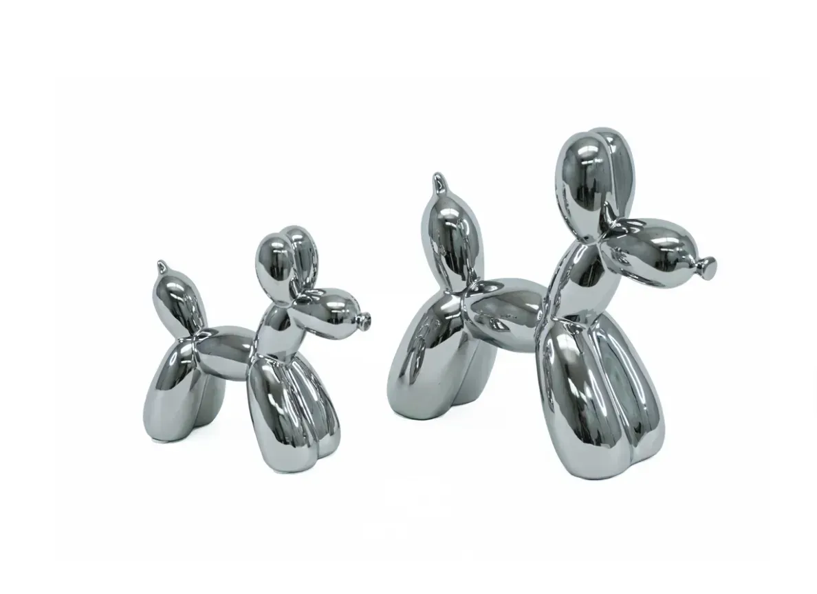 Two silver balloon dogs are sitting next to each other on a white background.