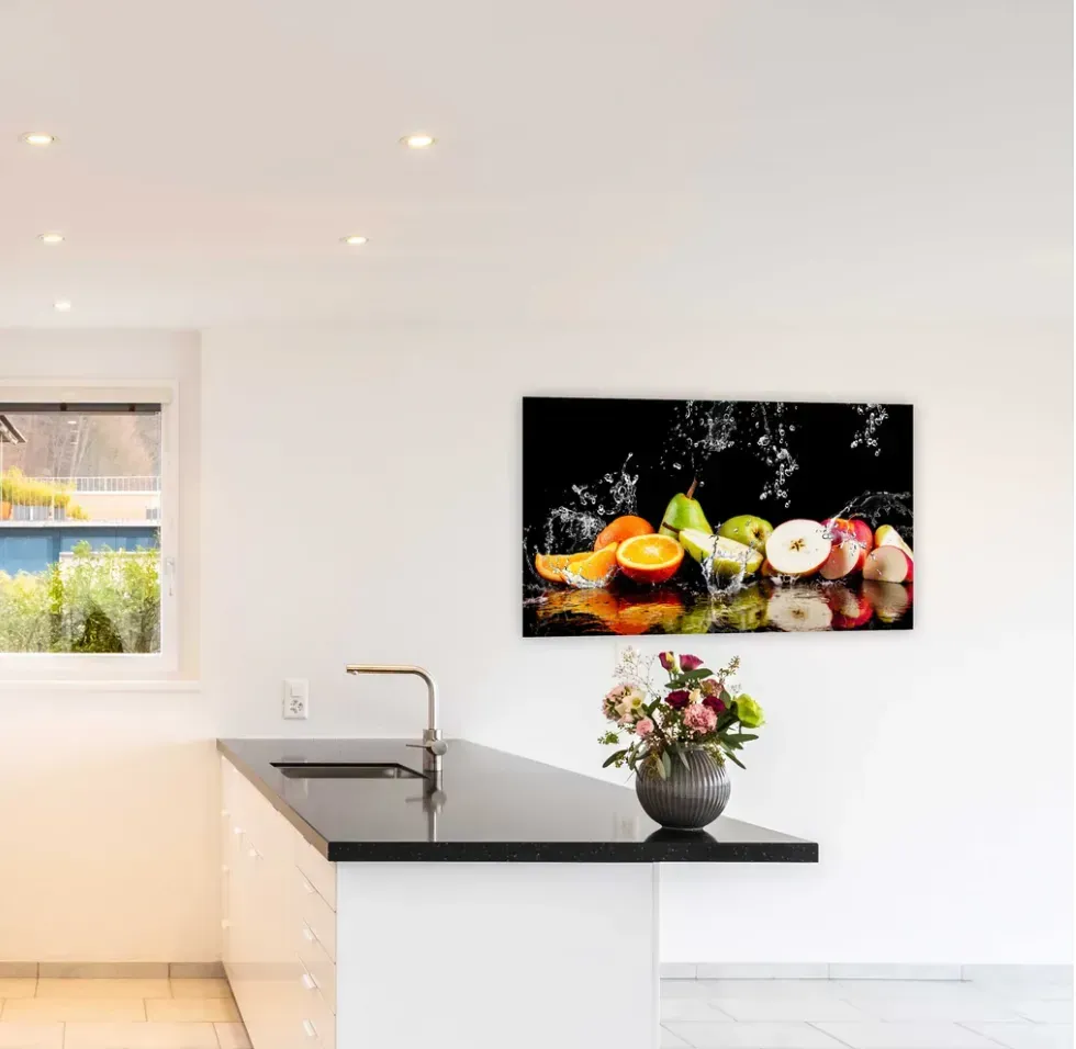 A kitchen with a picture of fruit on the wall above the counter