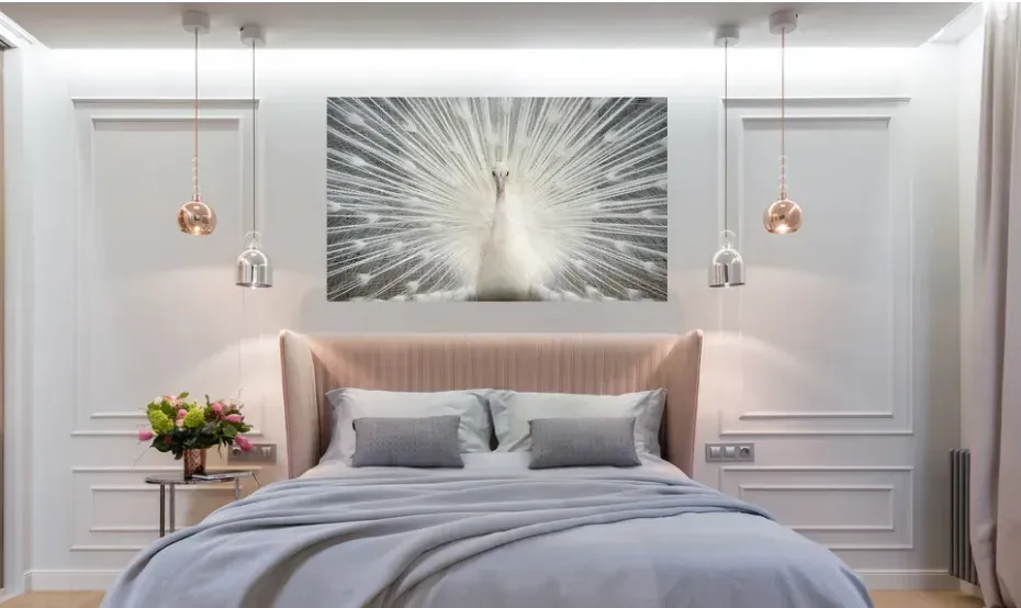 A bedroom with a bed and a painting of a peacock on the wall.