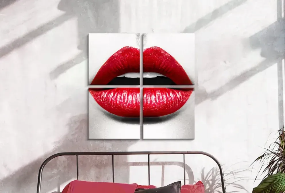 A painting of red lips is hanging on a wall above a bed.