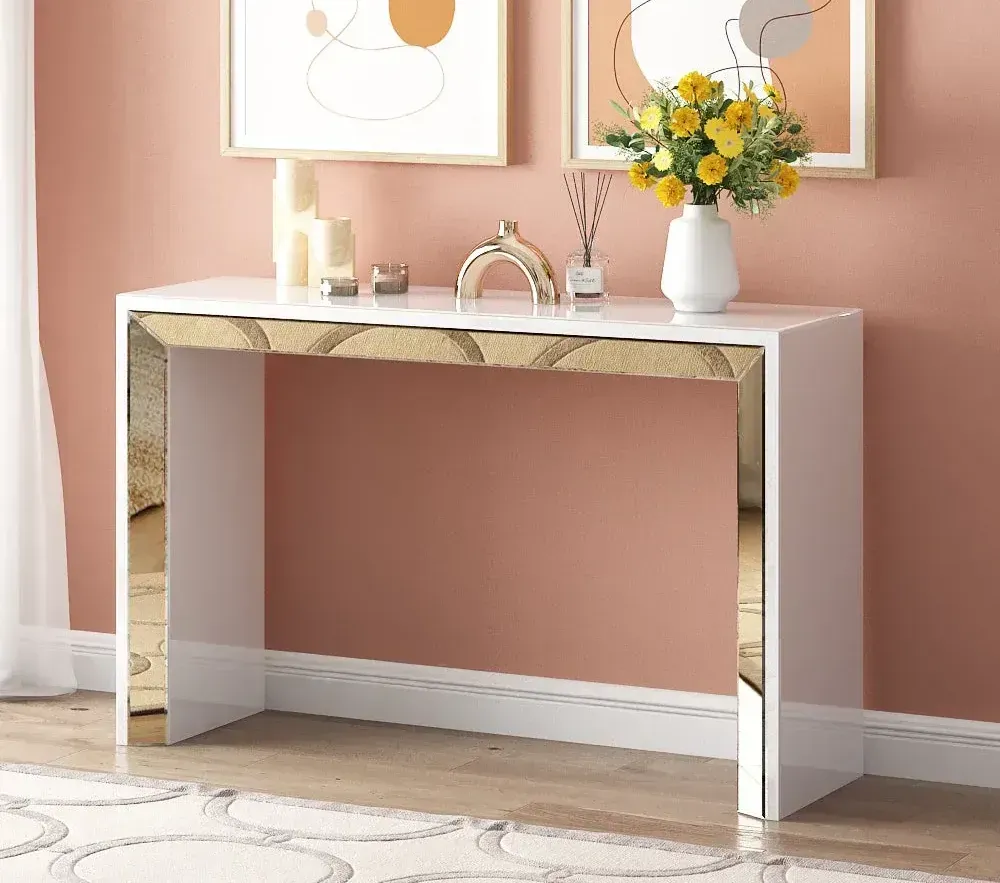 A white console table with a vase of flowers on top of it.