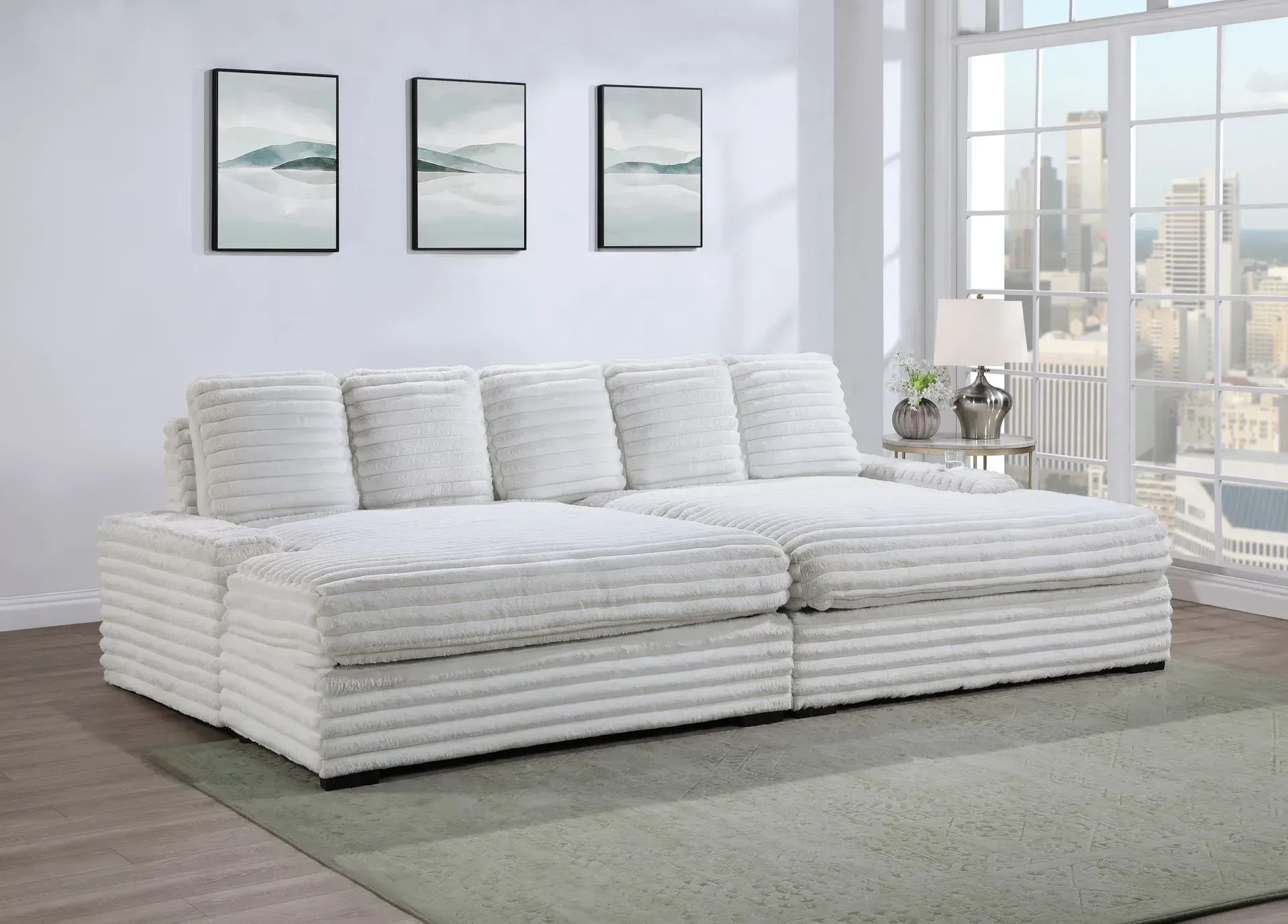 A white sectional couch is sitting in a living room next to a window.