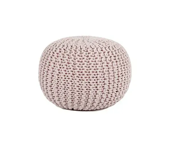 A white knitted ottoman is sitting on a white surface.