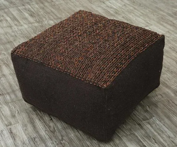 A brown ottoman is sitting on a wooden floor