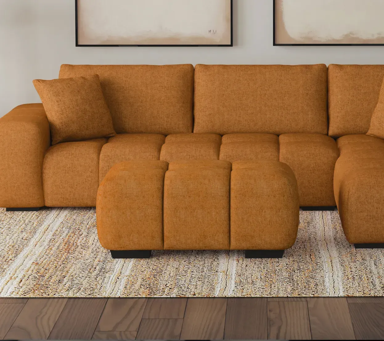 A living room with an orange sectional couch and ottoman