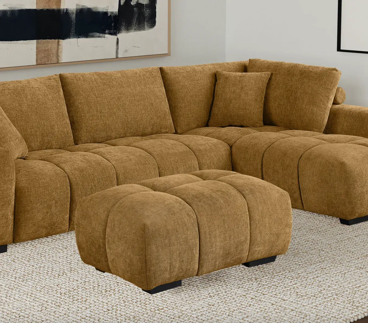 A living room with a brown sectional couch and ottoman