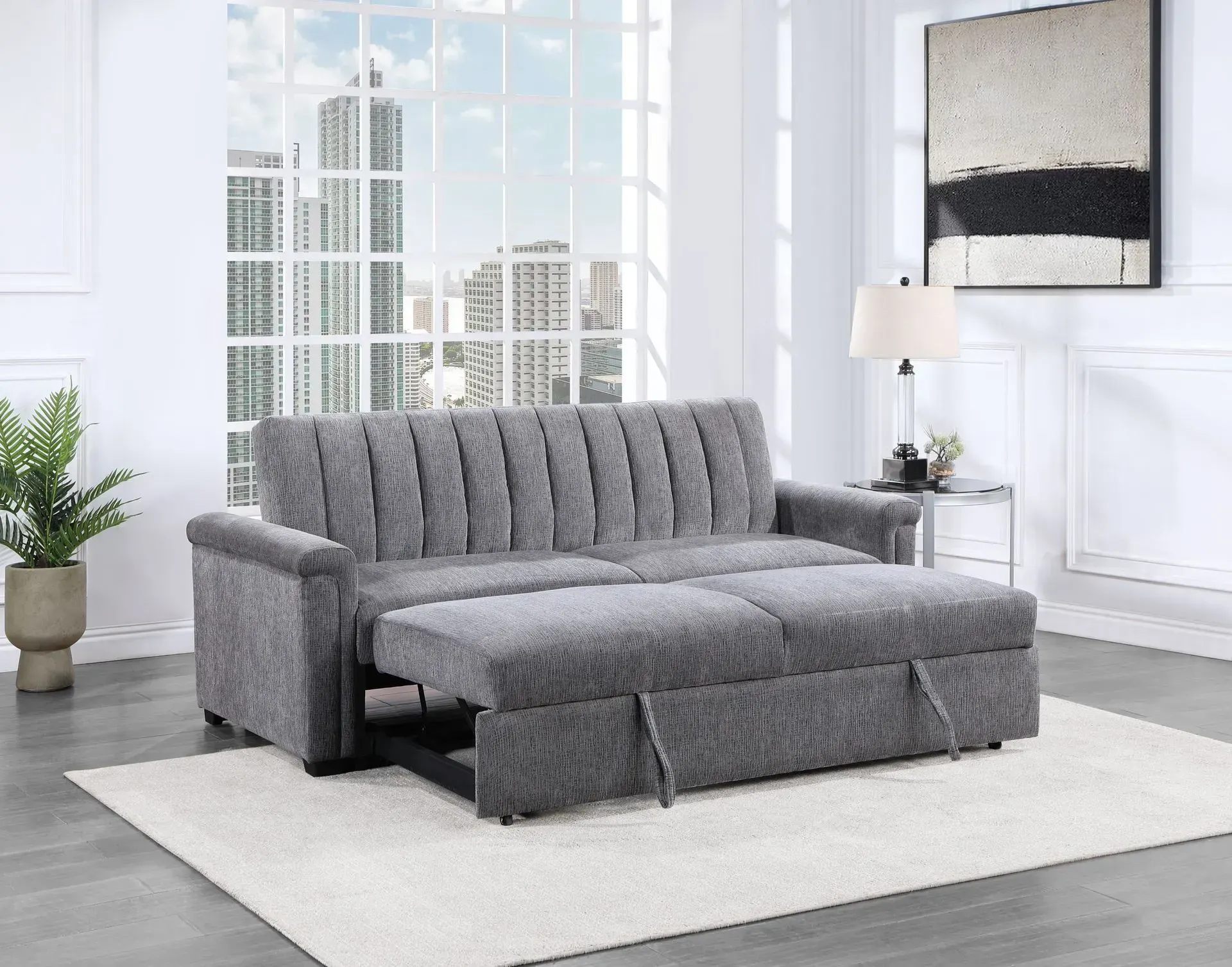 A gray couch is sitting on top of a white rug in a living room.