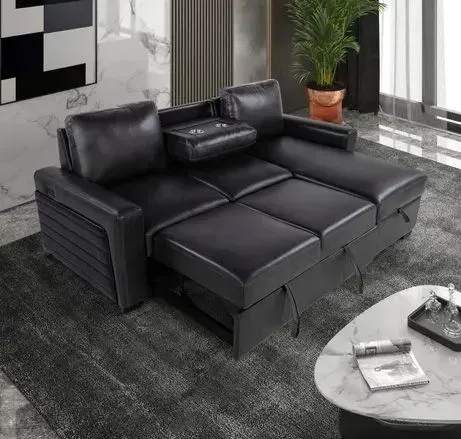 A black leather sectional couch is sitting in a living room next to a coffee table.