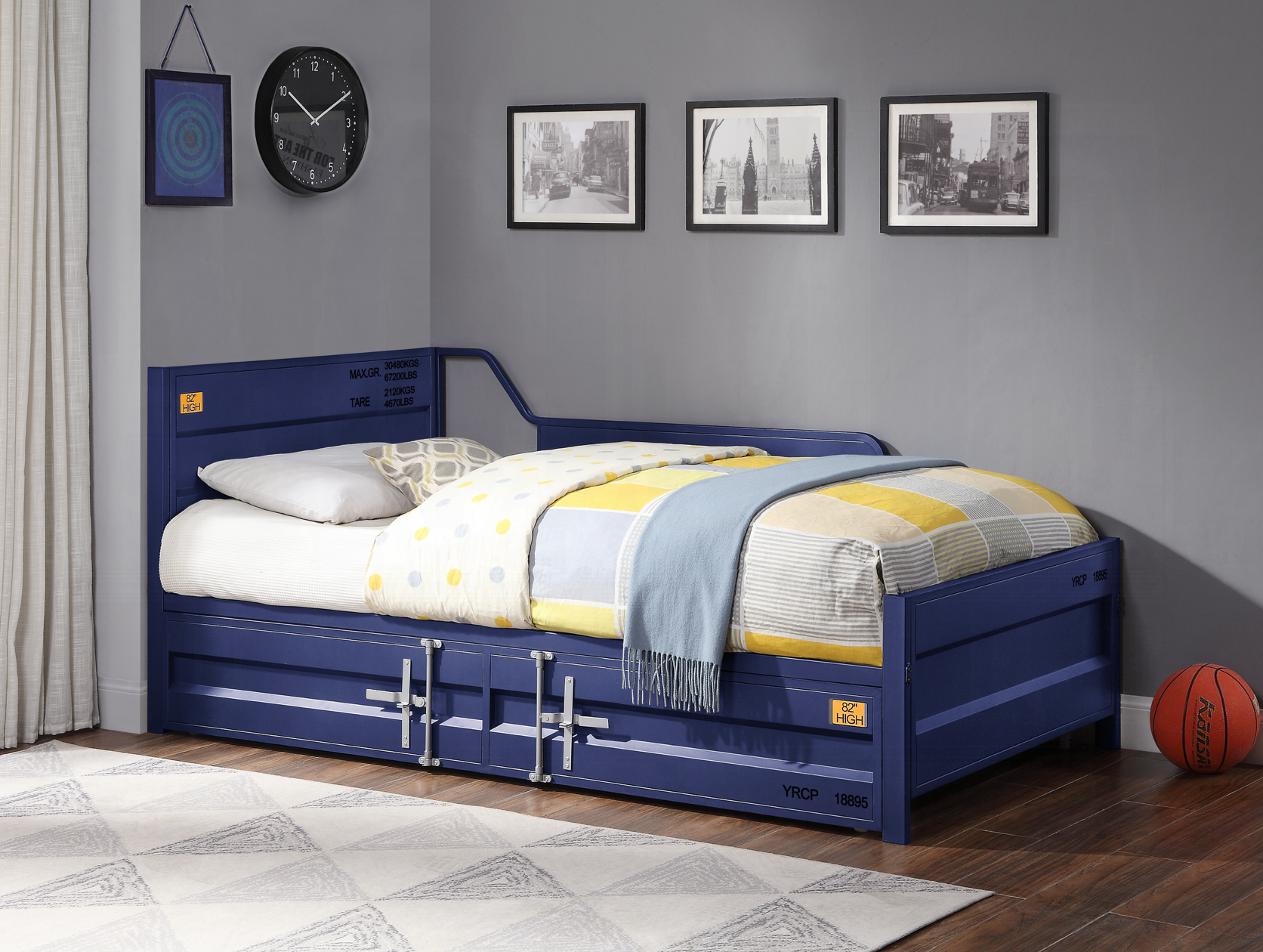 A blue day bed with drawers underneath it in a bedroom.