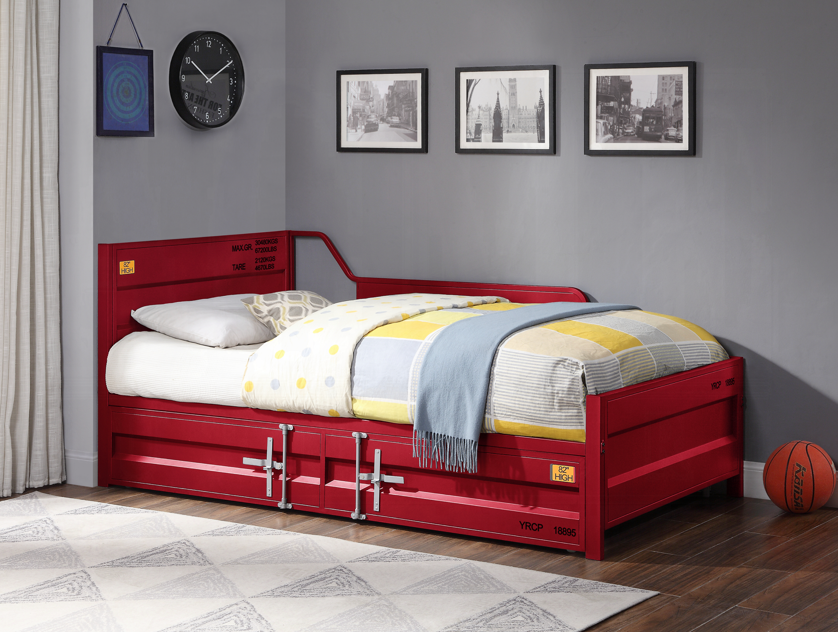A red day bed with drawers underneath it in a bedroom.