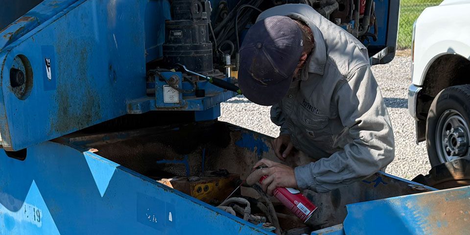 Mechanic performing on-site maintenance on a construction vehicle