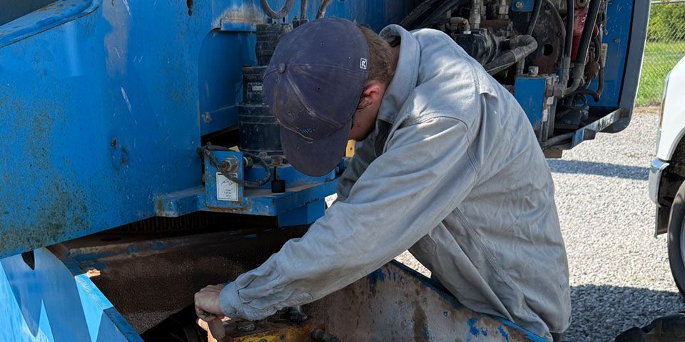Construction vehicle repair technician working on-site