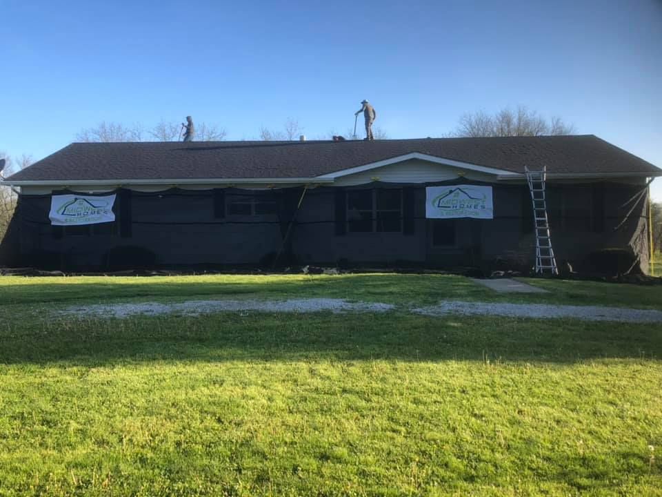 Two men are working on the roof of a house.