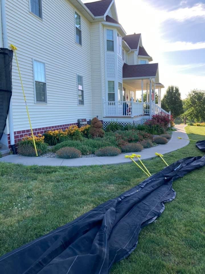 A large white house is sitting on top of a lush green lawn.