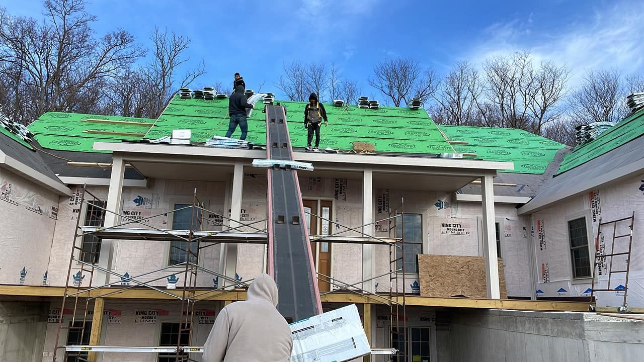 A group of people are working on the roof of a house.