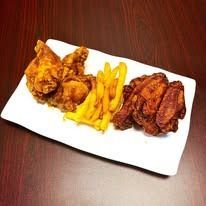 Fried chicken, fries, and wings on a white plate.