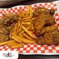 Fried chicken and french fries on a red and white checkered plate.