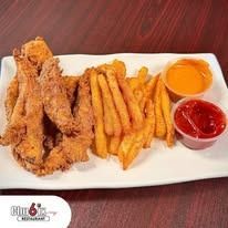 Fried chicken strips, fries, and dipping sauces on a white plate.