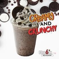 Creamy Oreo milkshake in a clear cup, with whipped cream and crushed cookies, 