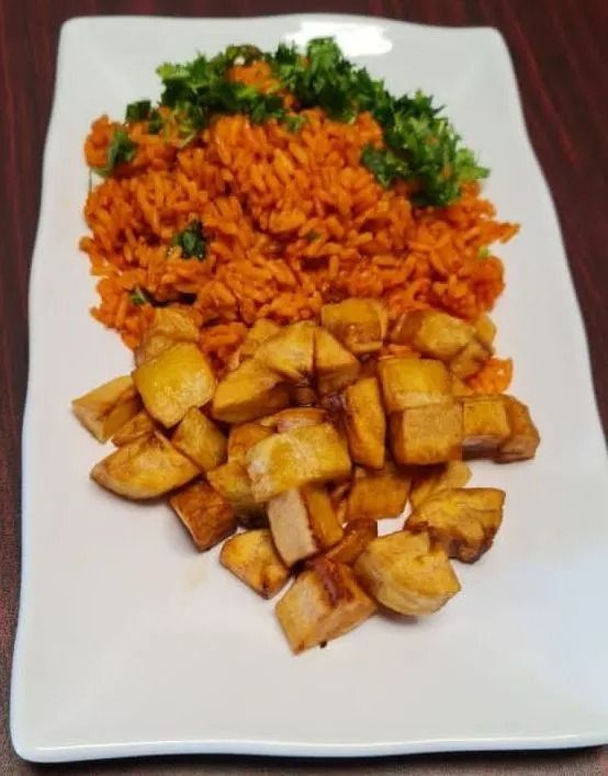 Plate with orange rice, fried plantains, and green garnish.